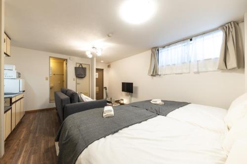 a bedroom with a bed and a living room at ユニオン新大阪 十三駅西中島南方駅 自転車&wifi貸出無料 in Osaka