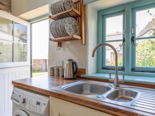 eine Küche mit einem Waschbecken und einem Fenster in der Unterkunft End Cottage in Kingsbridge