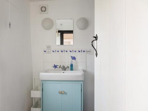 a bathroom with a blue cabinet and a sink at Rose Thatch in Kingsbridge