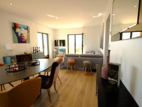 un salon avec une table et un canapé dans l'établissement Le pavillon d'Eole-loft vue mer exceptionnelle, à Réville