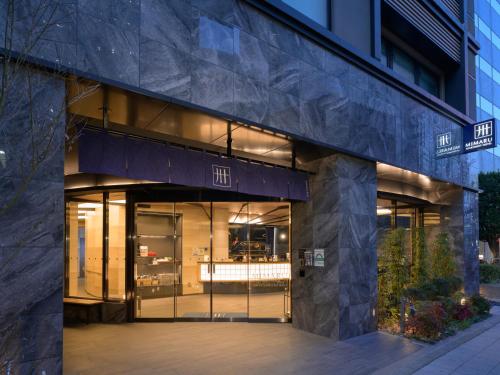 una entrada a un edificio con puertas de cristal en MIMARU TOKYO SHINJUKU WEST en Tokio