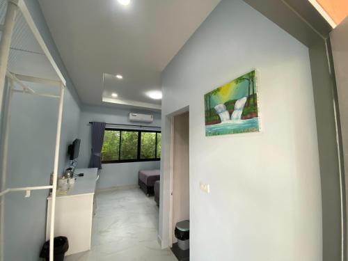 a hallway of a house with a painting on the wall at I AM Cottage เฮือนแก้วมณี in Nakhon Pathom
