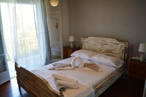 1 dormitorio con 1 cama con 2 toallas en Afroditi first floor apartment, en Achílleion