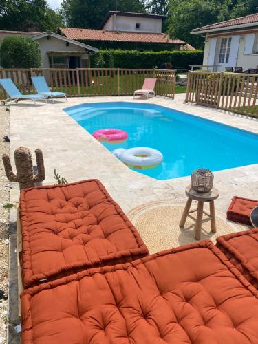 una piscina con dos frisbees en un patio en Villa Belharra en Beychac-et-Caillau