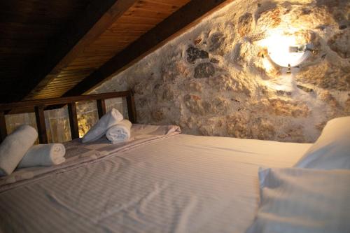 a bed in a room with a stone wall at Anna's Garden in Triandafilliá