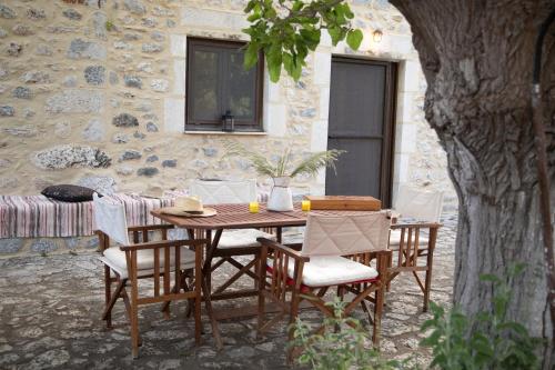 a wooden table and chairs in front of a building at Anna's Garden in Triandafilliá