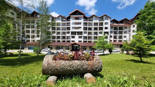 a large building with a flower pot in the grass at The Green apartment in Borovets