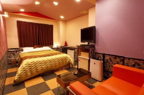 a bedroom with a bed and a tv and a couch at ブルーリバー1991 in Fukuoka
