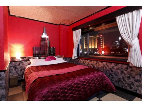 ブルーリバー1991 في فوكوكا: غرفة نوم حمراء بها سرير ونافذة