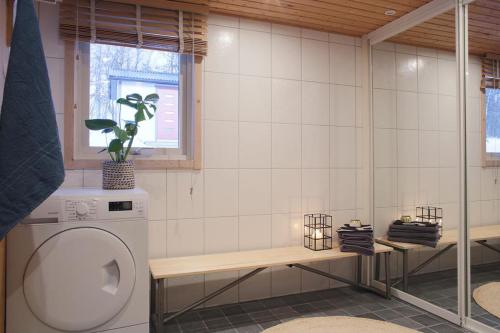 a bathroom with a washing machine and a window at Aurora Cabin in Kiruna