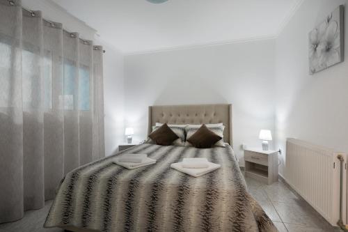 1 dormitorio con 1 cama grande y 2 platos blancos. en MTC-Sea & sky by Valeria near airport en Porto Rafti