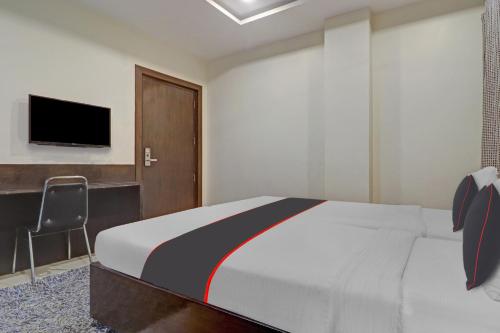 Dormitorio con cama, escritorio y TV en Collection O 81197 Hotel Star Inn, en Hyderabad