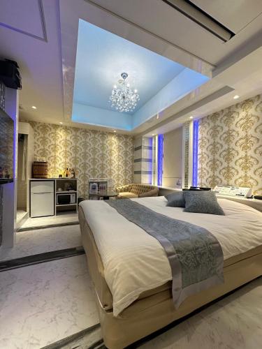 a large bedroom with a large bed and a chandelier at HOTEL EXE (Adult Only) in Tokyo