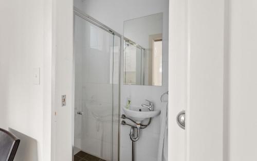 a bathroom with a glass shower with a sink at No.8 - The Block in Victor Harbor