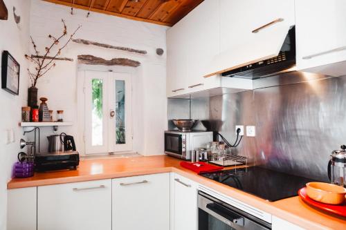 una cucina con armadi bianchi e piano cottura di JAJA Studios Paros a Paroikia