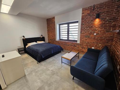 a bedroom with a bed and a brick wall at Karpacka 8 in Bydgoszcz