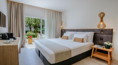 Melissi Beach Hotel & Spa في أيا نابا: غرفة نوم بسرير كبير وبلكونة
