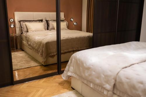 a bedroom with a mirror next to a bed at Bristol Apartment in the Centre of Zagreb in Zagreb