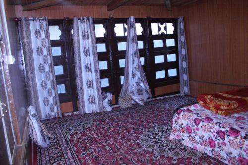 um quarto com cortinas, uma cama e uma janela em POP Shabnam Homestay 