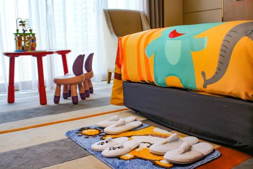 a bedroom with a bed with shoes on the floor at Pullman Zhuhai in Zhuhai