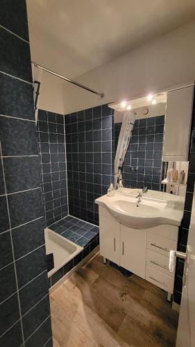 a bathroom with a sink and a shower and a mirror at Ferienwohnung Bergwichtel Hahnenklee "super Aussicht" in Hahnenklee-Bockswiese