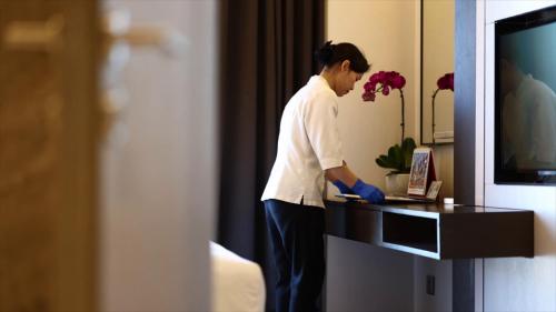 a woman standing at a desk in a hotel room at Pullman Zhuhai in Zhuhai