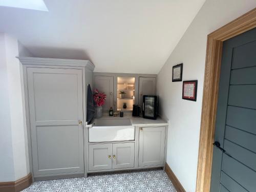 a kitchen with a white sink and a microwave at New Converted Barn in Hereford