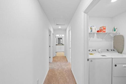 una cocina blanca con armarios blancos y un pasillo en Spacious Modern Home with King Beds near Disney, en Davenport