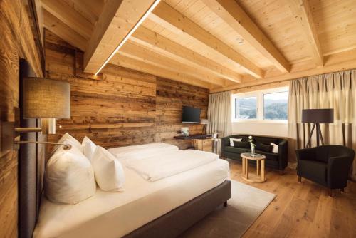 a bedroom with a bed in a room with wooden walls at Torghele's Wald & Fluh in Balderschwang