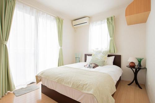 una camera da letto con un grande letto con tende verdi di The Wisteria ad Osaka