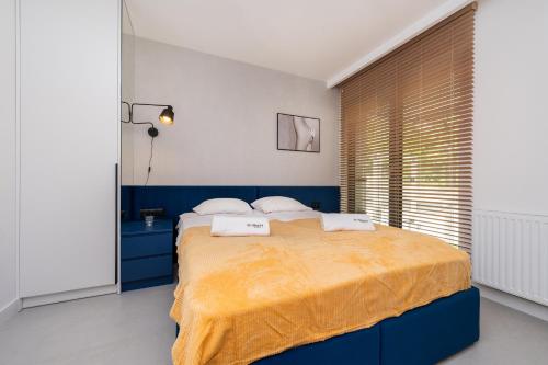 1 dormitorio azul y blanco con 1 cama grande en Monte BillBerry Apartments, en Sopot