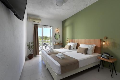 Un dormitorio con una cama grande y una ventana en Charm Hotel, Hersonissos, en Hersonissos