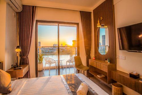 プノンペンにあるM9 Kirirom Hotelのベッド、テレビ、バルコニーが備わるホテルルームです。