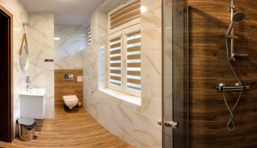 uma casa de banho com um chuveiro e um WC. em Maria em Rymanów-Zdrój