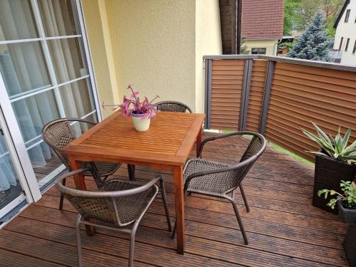 a wooden table and chairs on a deck at Ferienwohnung Gretel in Görlitz