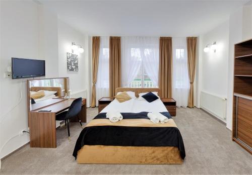 ein Hotelzimmer mit einem Bett und einem Schreibtisch in der Unterkunft Maria in Rymanów-Zdrój