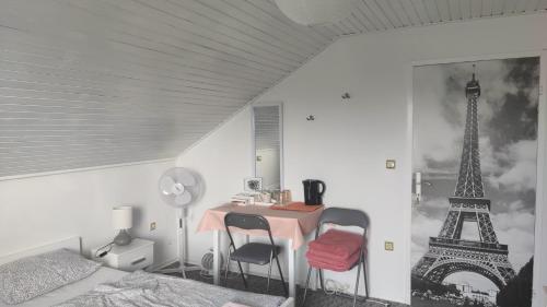 1 dormitorio con mesa y torre eiffel en CELINKA rooms, en Raka