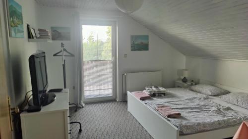 1 dormitorio con 1 cama y TV en CELINKA rooms, en Raka
