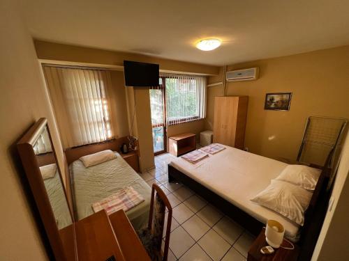 ブルガスにあるDvete Breziのベッド2台とテーブルが備わる小さな客室です。