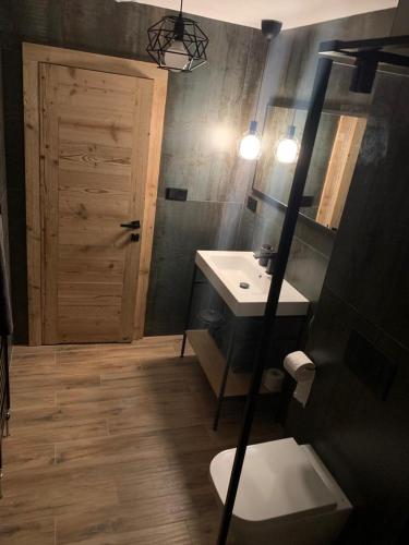a bathroom with a sink and a toilet and a mirror at Apartmany FABRIK in Vysoká nad Kysucou