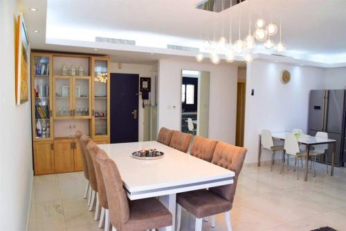 une salle à manger avec une table et des chaises blanches dans l'établissement Luxury 120m2 in city center, Best location!, à Jérusalem
