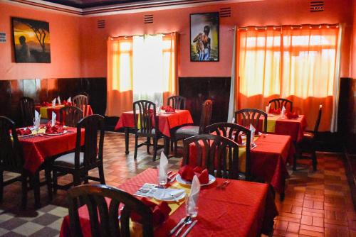 ein Restaurant mit roten Tischen und Stühlen in einem Zimmer in der Unterkunft Sundowner Lodge in Nakuru