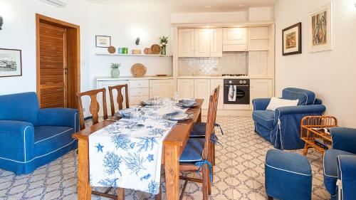 cocina con mesa de comedor y sillas azules en Welcomely - Retiro Perpignan, en Alghero