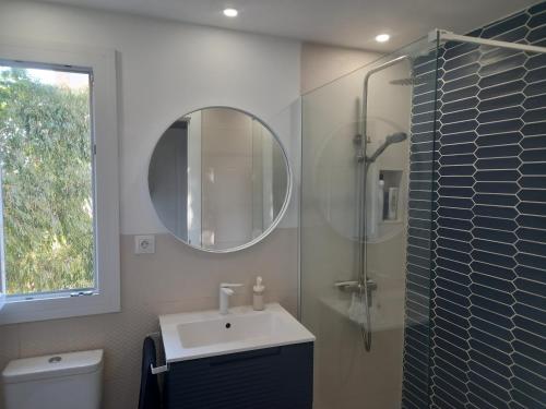 y baño con lavabo y ducha con espejo. en Apartamento Los Álamos Totalmente reformado Junio 2023 en Torremolinos