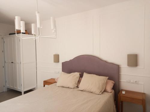 a bedroom with a bed with two pillows on it at Apartamento Los Álamos Totalmente reformado Junio 2023 in Torremolinos