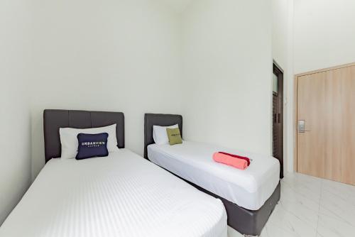 Postel nebo postele na pokoji v ubytování Urbanview Hotel La De Grizz Syariah Sampit by RedDoorz
