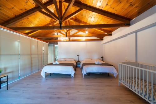 a bedroom with four beds and a wooden ceiling at Villa Ambrosia, beach house, Platanidia, Pelion in Platanidia