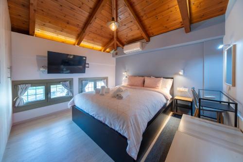 a bedroom with a large bed in a room with wooden ceilings at Villa Ambrosia, beach house, Platanidia, Pelion in Platanidia