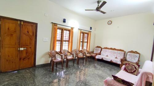 a waiting room with a bunch of chairs and a door at Kurumbalakotta Village Homestay in Padinjarathara