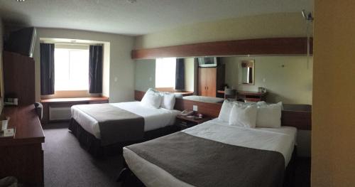 a hotel room with two beds and two windows at Microtel Inn & Suites Beckley East in Beckley